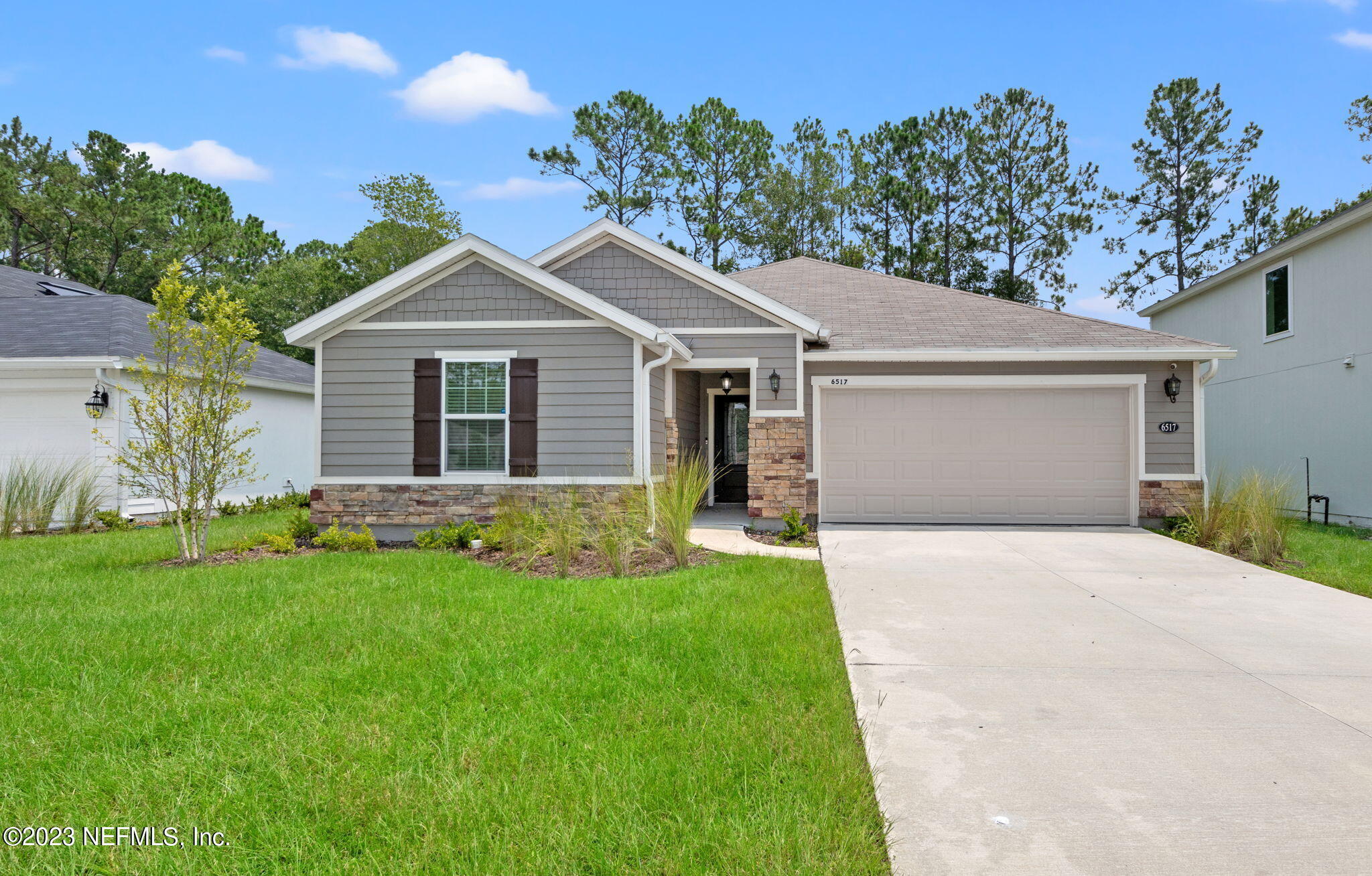 a front view of a house with a garden and yard