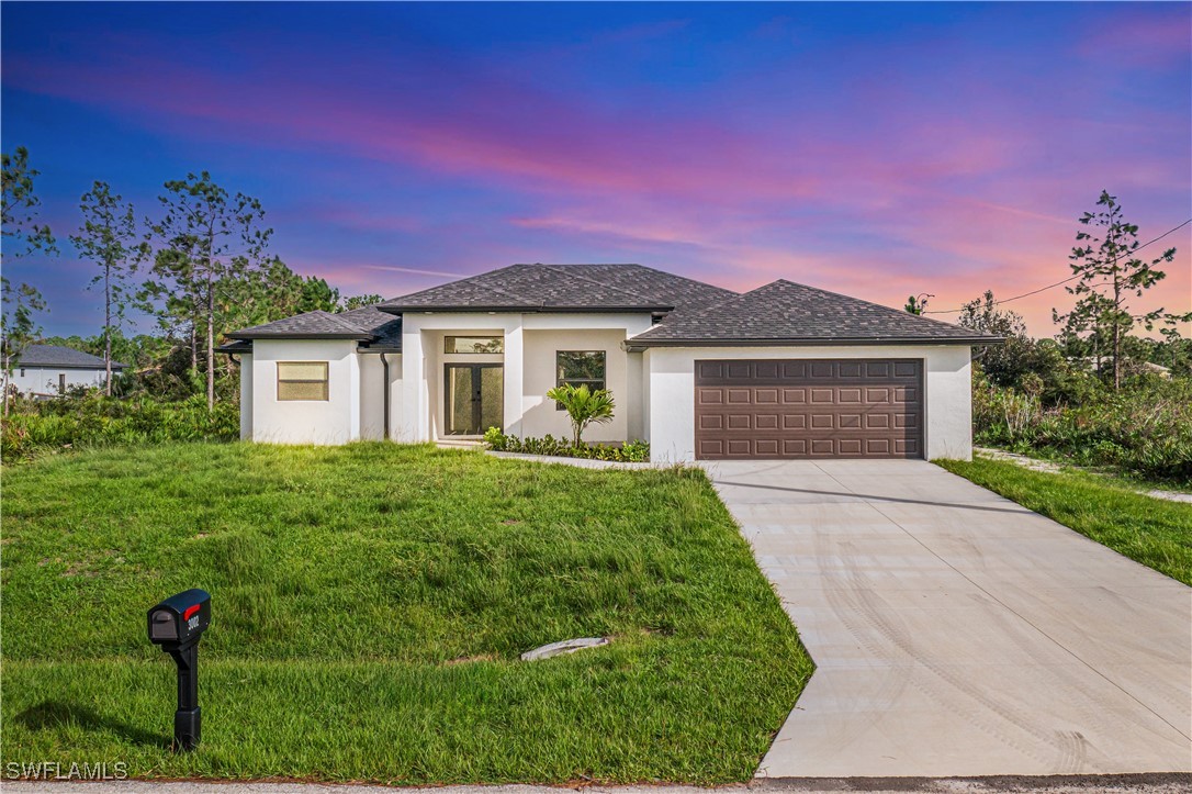 a front view of a house with a yard and garage