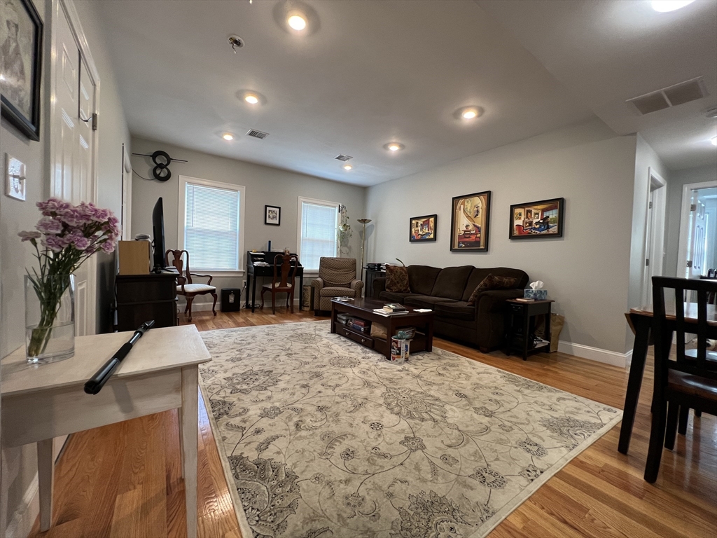 a living room with furniture a dining table and a flat screen tv