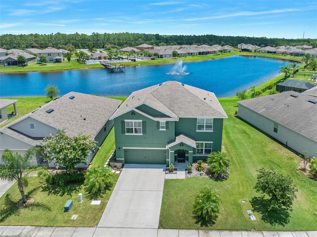 an aerial view of a house with a garden and lake view