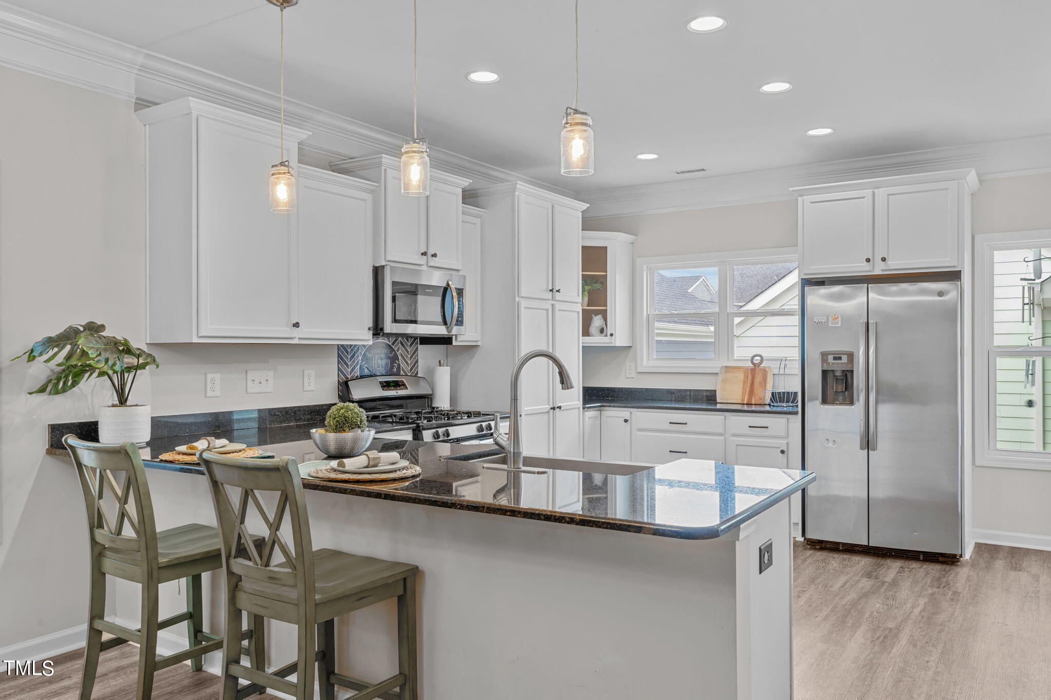 a kitchen with stainless steel appliances granite countertop a refrigerator and a stove top oven