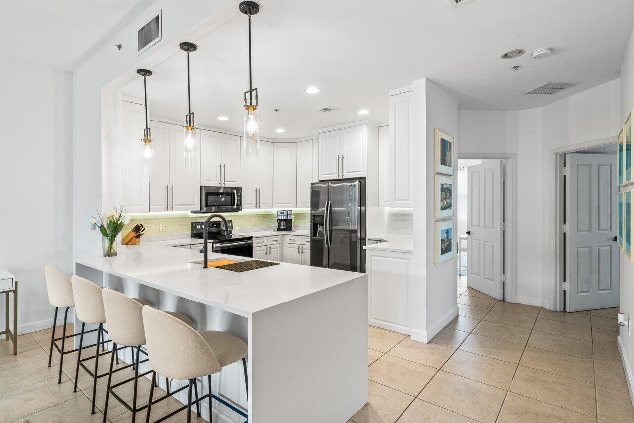 a kitchen with stainless steel appliances a refrigerator sink and microwave