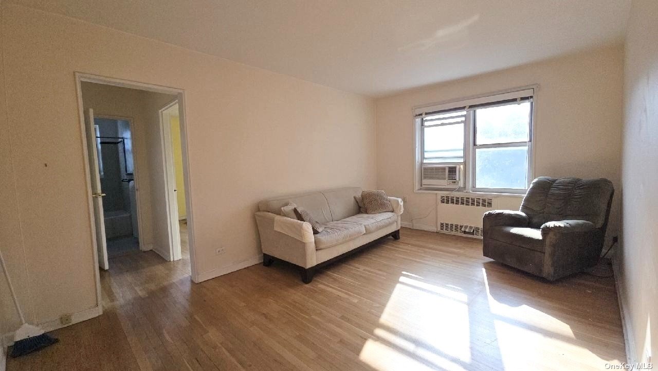 a living room with couches and a window with wooden floor