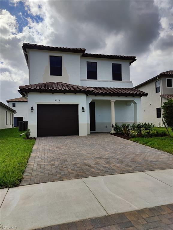 a front view of a house with a yard and a garage