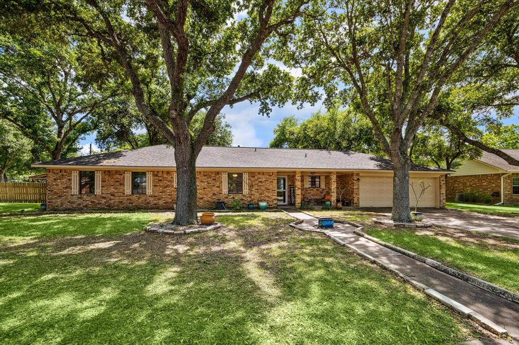 a front view of a house with yard tree and green space