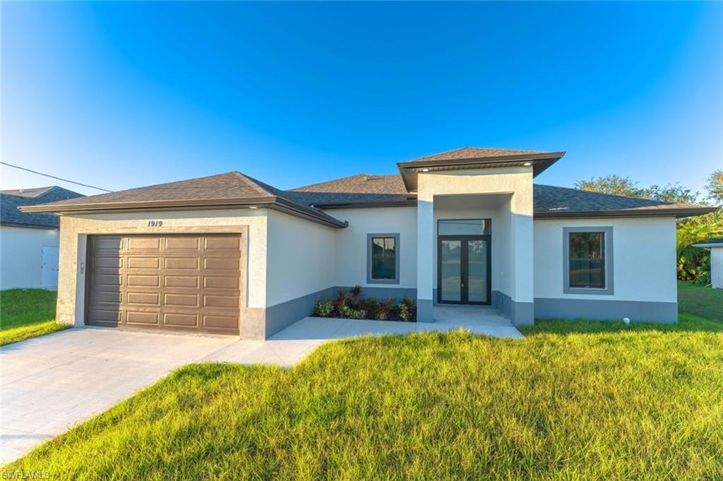 Prairie-style home featuring french doors, a front lawn, and a garage