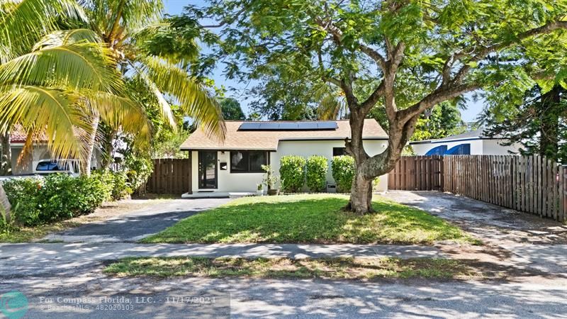 a front view of a house with a yard and tree