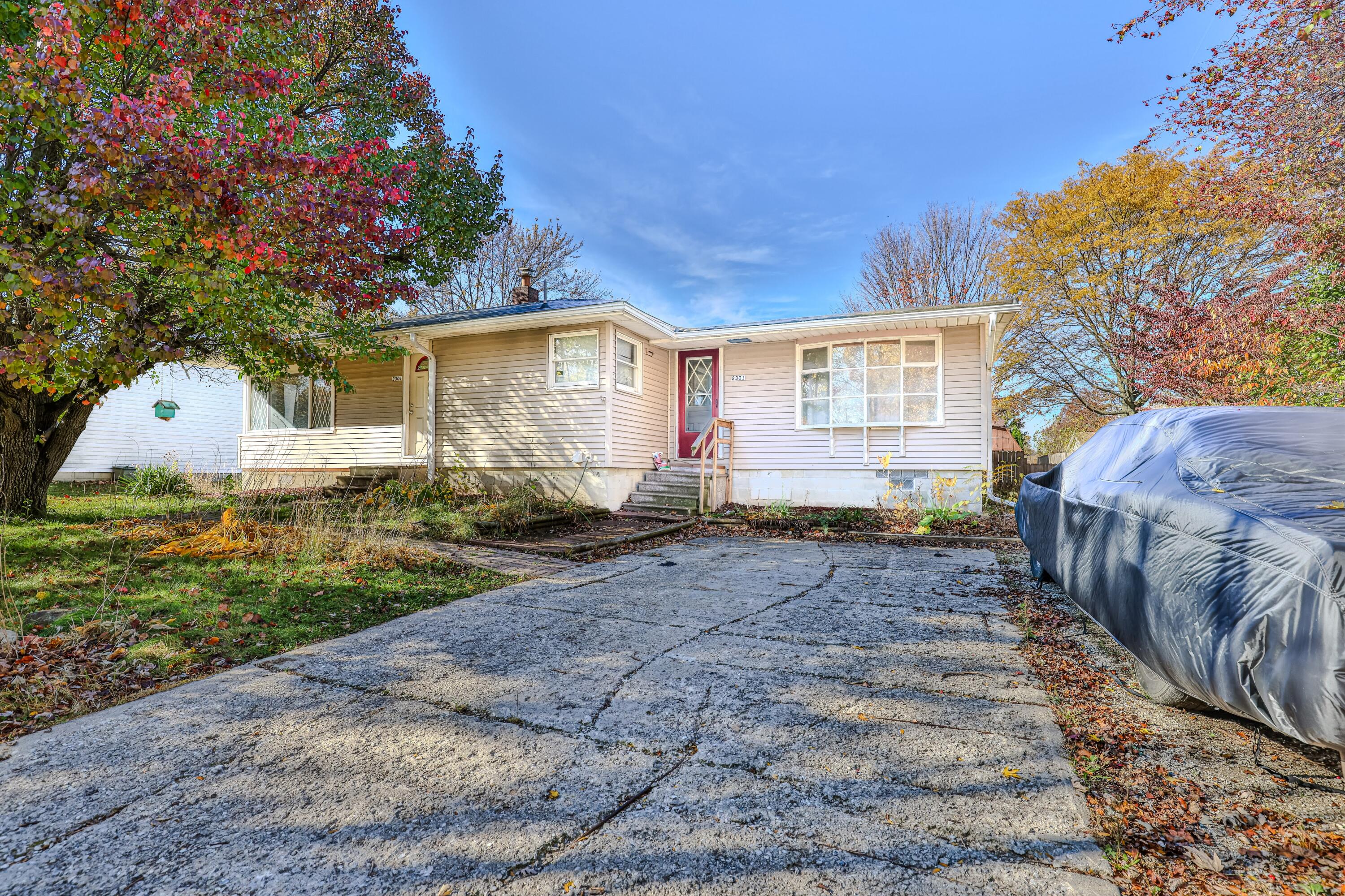 a front view of a house with a yard and trees