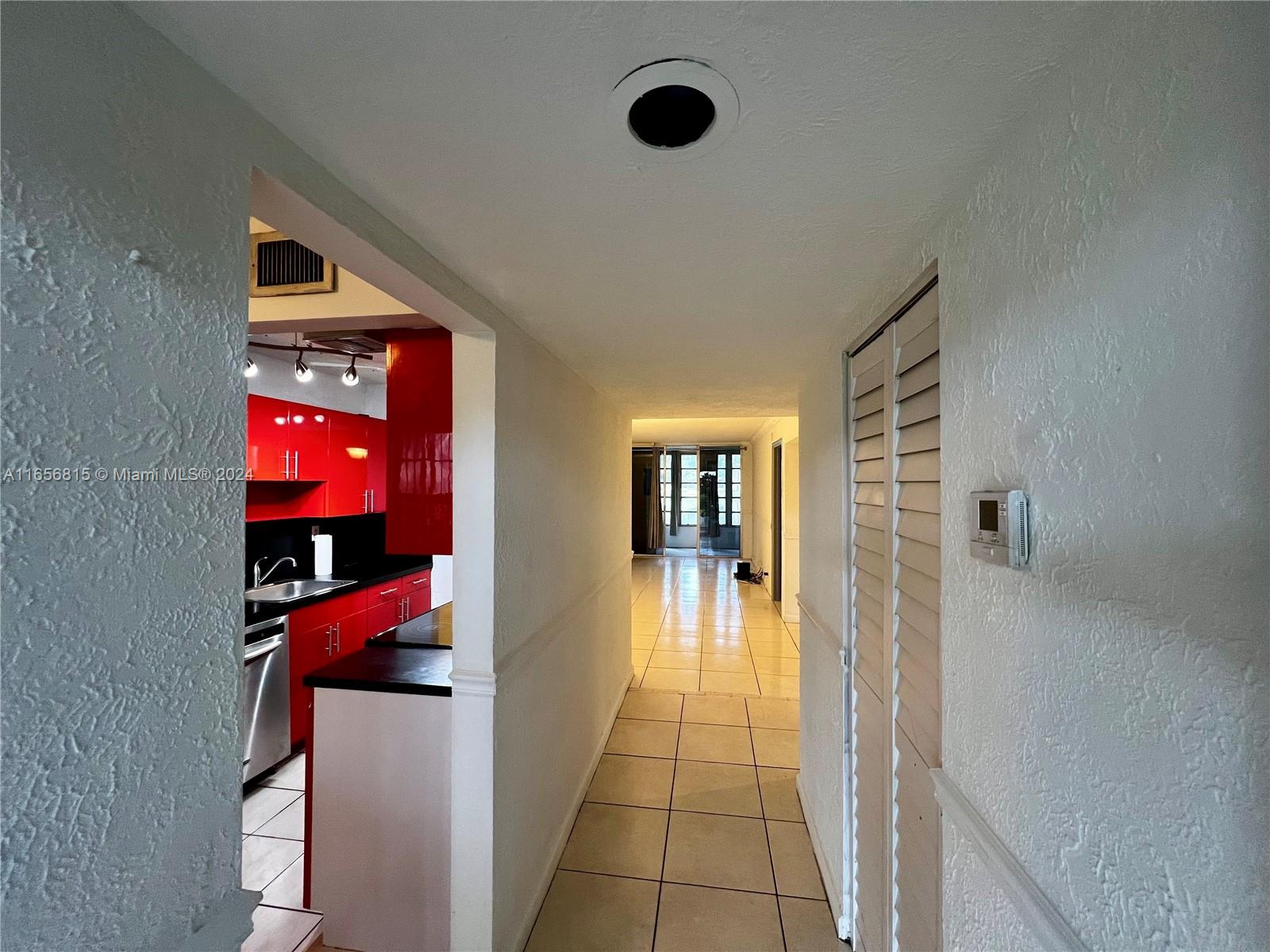 a view of a hallway to a livingroom with furniture