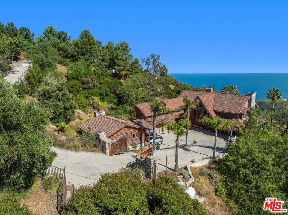 an aerial view of a house with swimming pool and outdoor seating