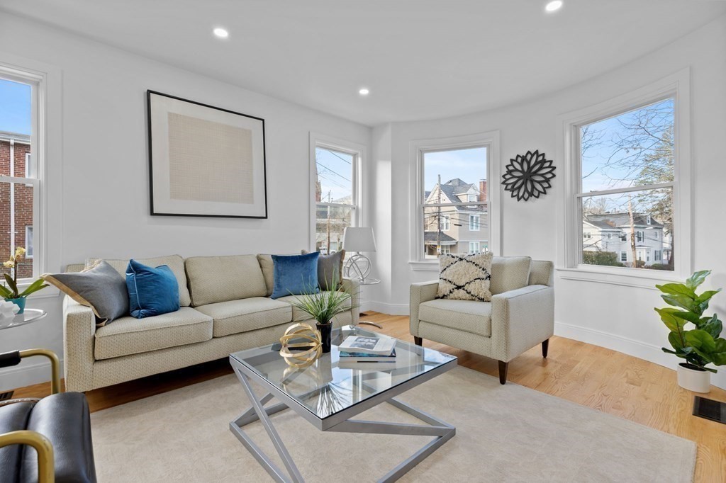 a living room with furniture and a large window with garden view