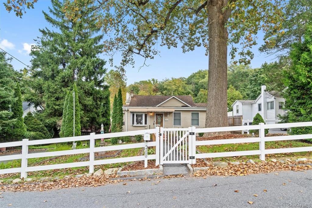 a view of a house with a backyard and a large tree