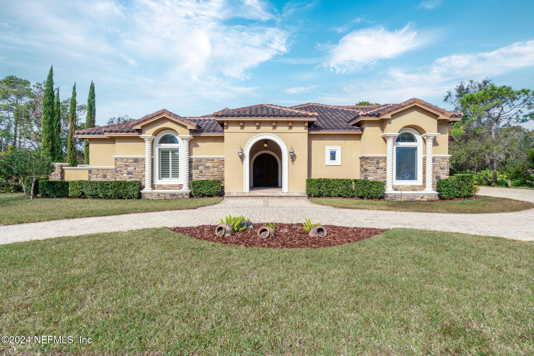 a front view of a house with a garden