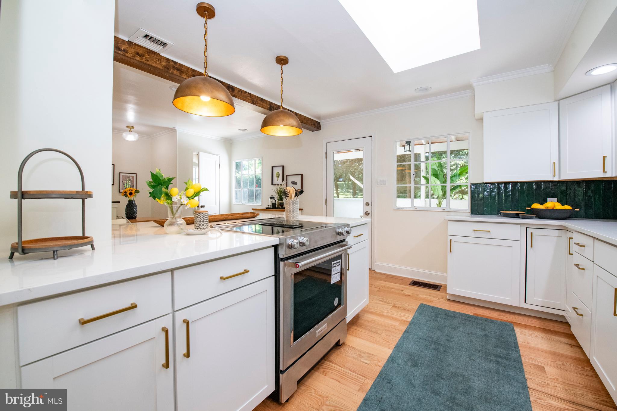 a kitchen with stainless steel appliances granite countertop a stove a sink and a wooden floor