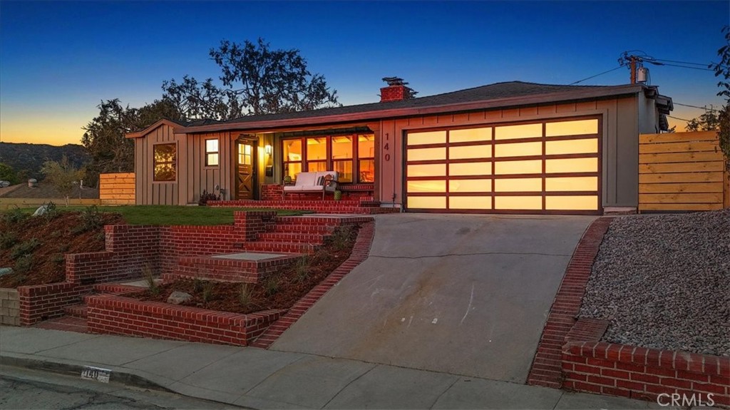 Front featuring new siding and custom glass garage door