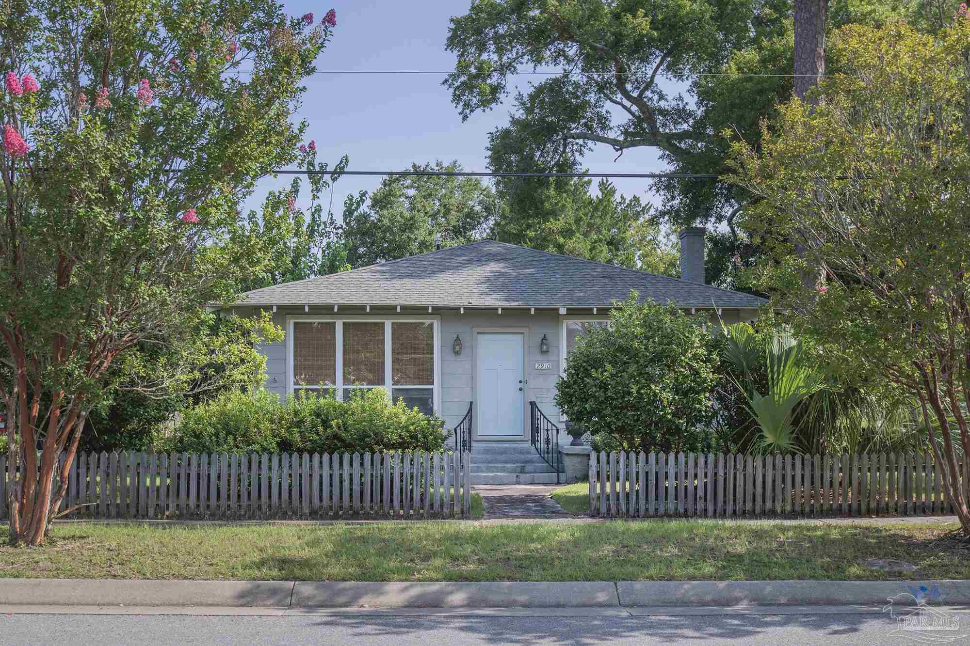 a front view of a house with a garden