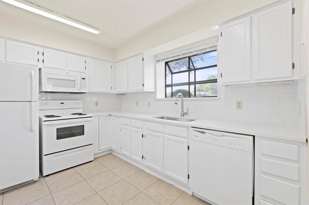 a kitchen with granite countertop white cabinets and white appliances