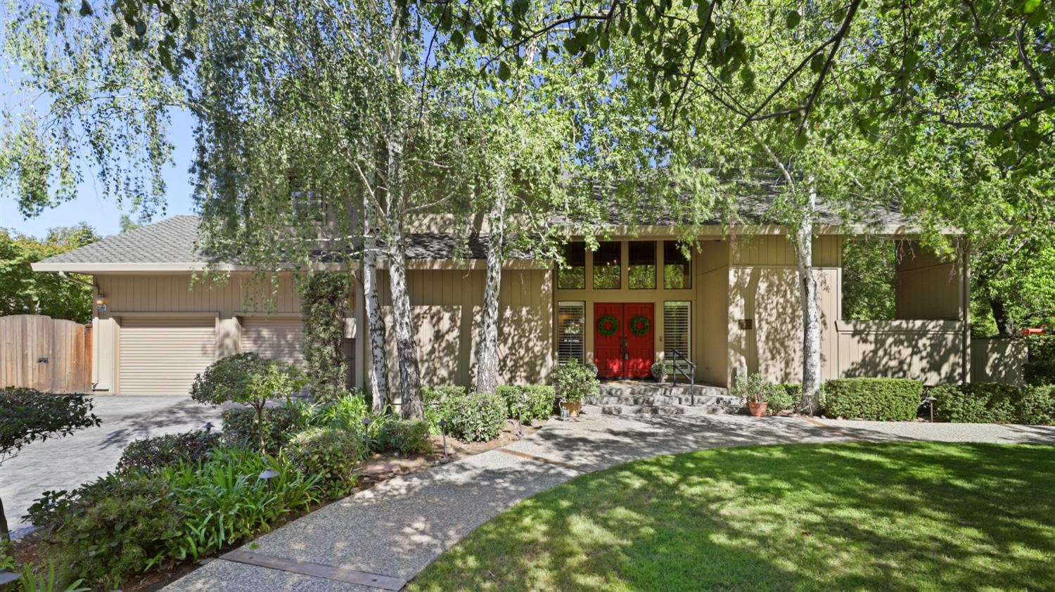 a front view of a house with a yard and trees