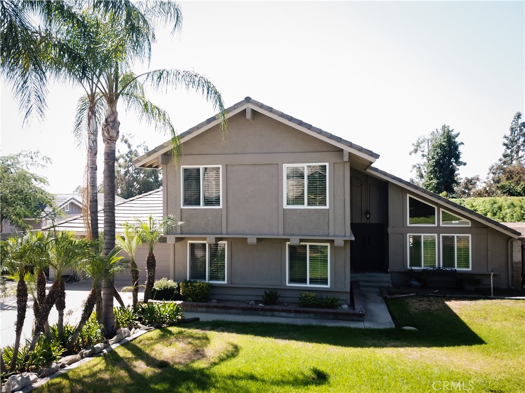 a front view of a house with yard and trees around