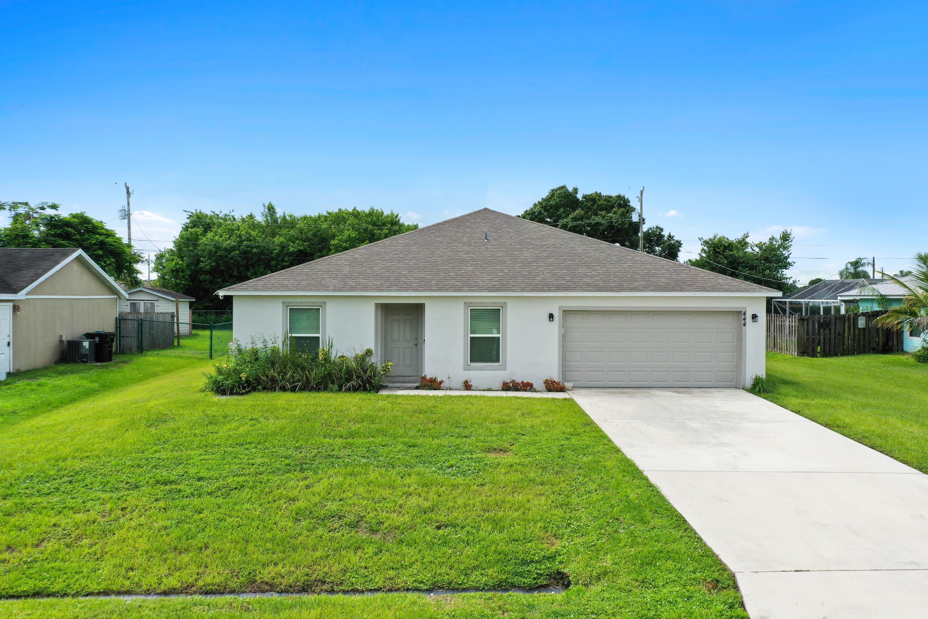 a front view of a house with yard and green space