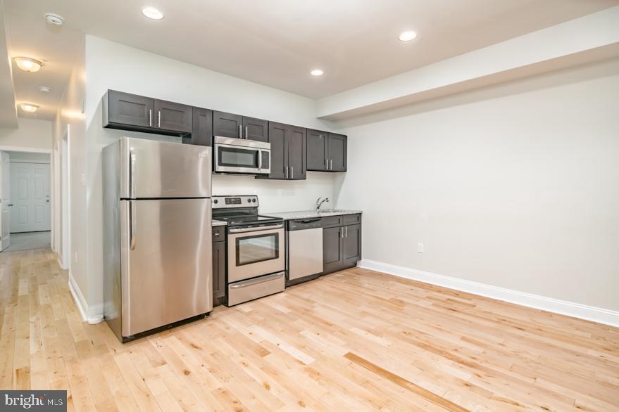 a kitchen with stainless steel appliances a refrigerator and a stove top oven