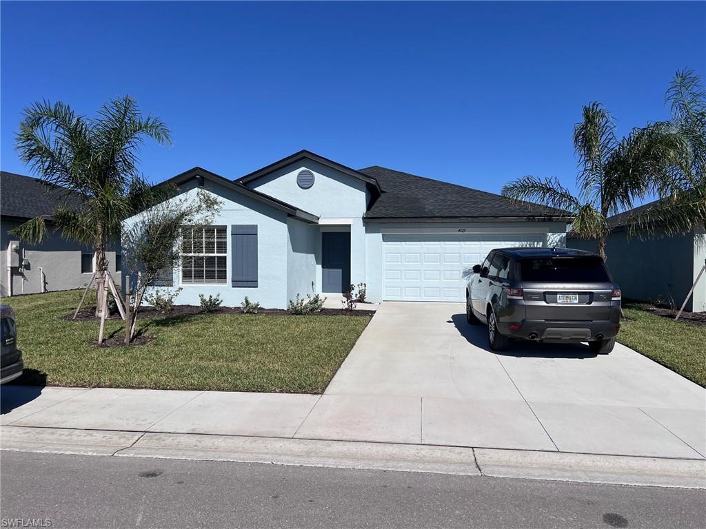 Single story home featuring a front yard and a garage