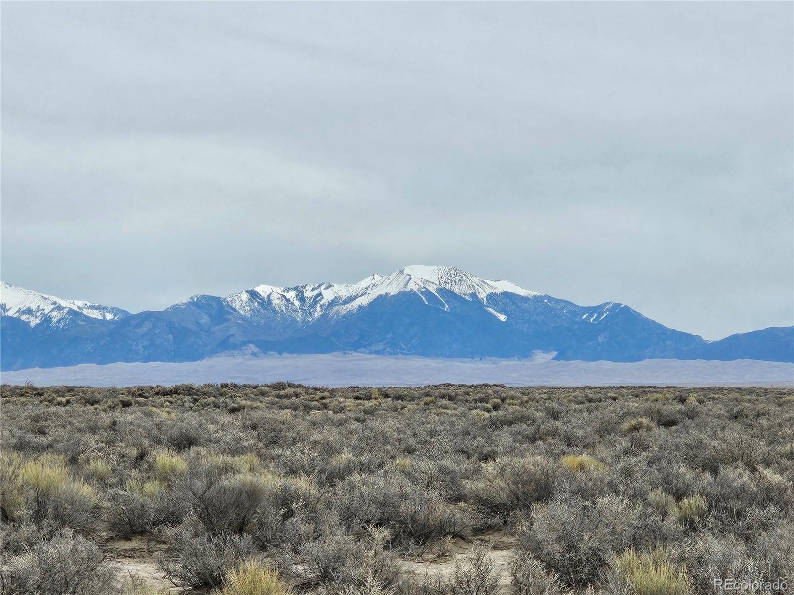 a view of a large mountain with mountains in the background