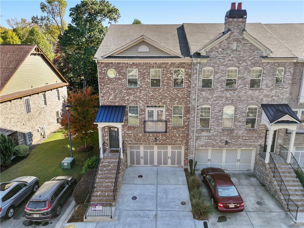 a view of a brick house with many windows next to a yard