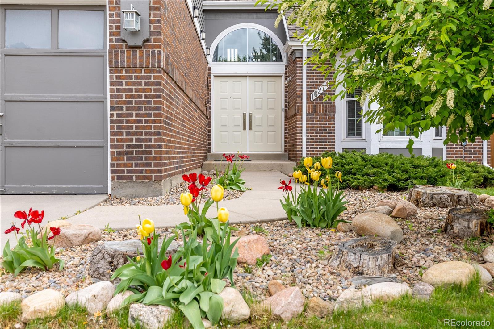 a front view of a house with lots of flowers