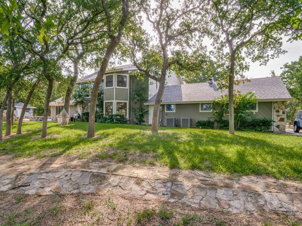 a front view of a house with a yard and trees