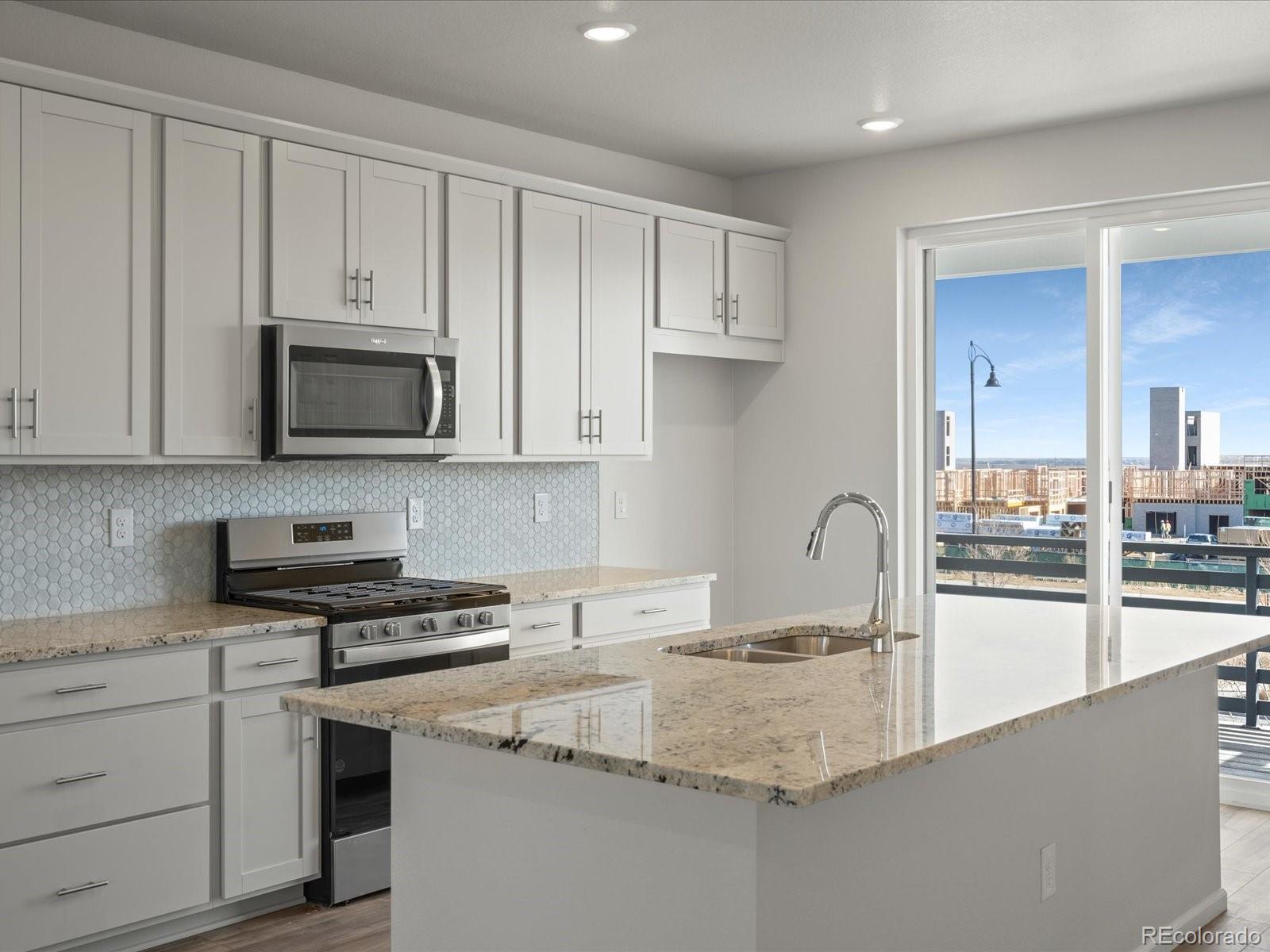 a kitchen with stainless steel appliances granite countertop a sink a stove and cabinets