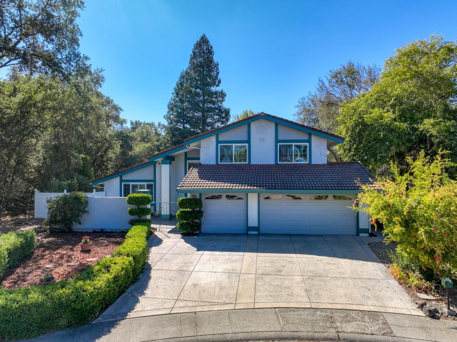 a front view of a house with a yard and trees