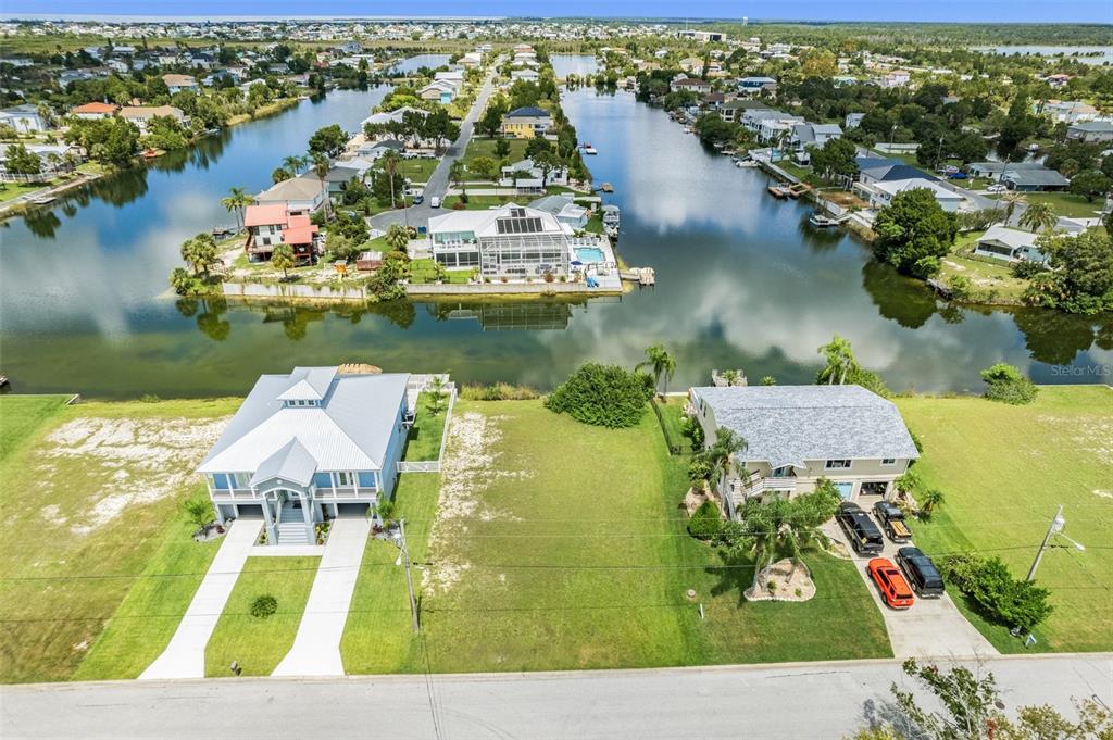 an aerial view of residential houses with outdoor space and lake view