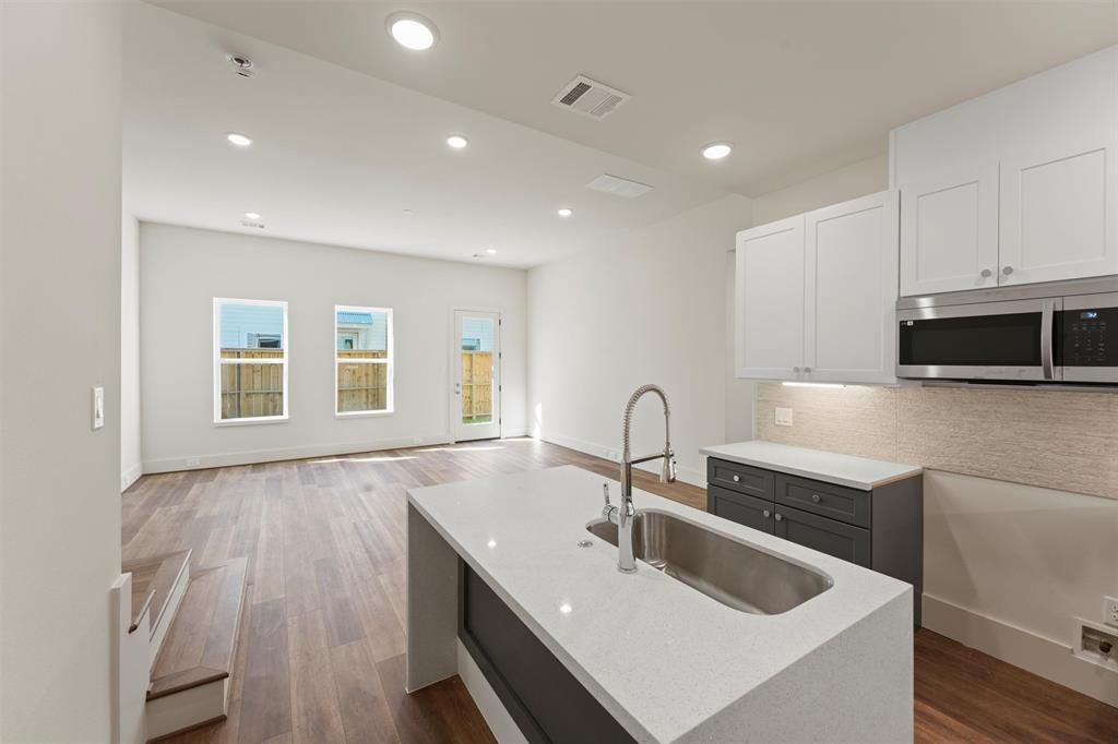 a kitchen with a sink microwave and cabinets