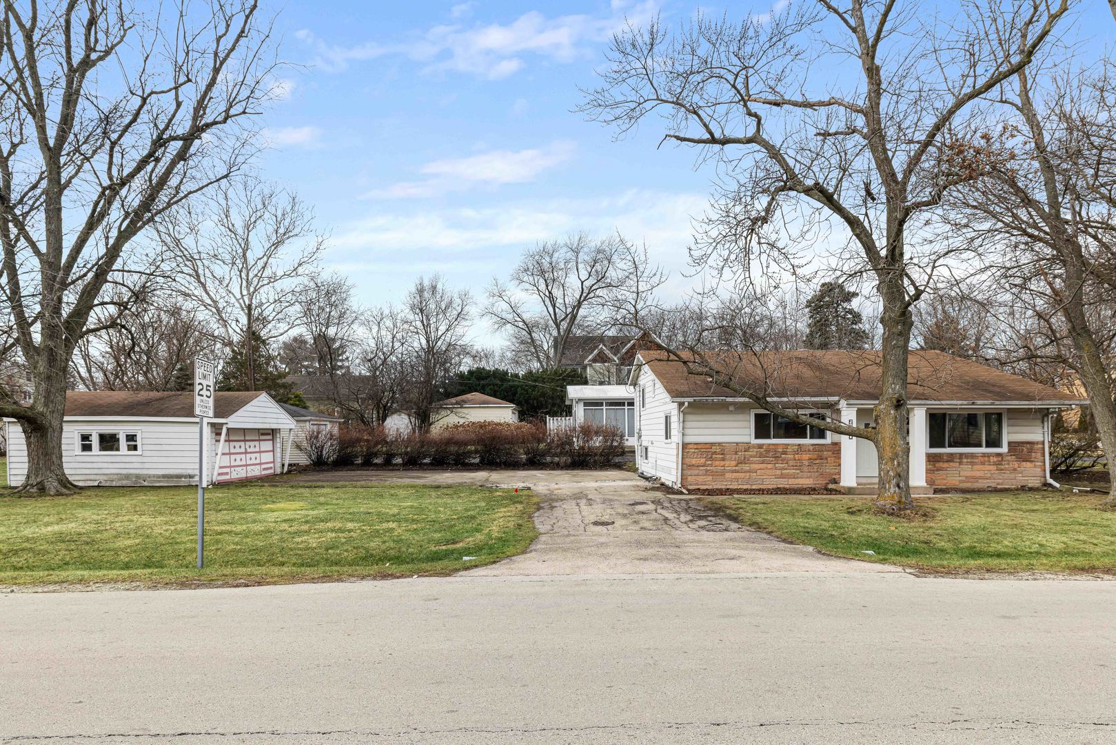 a view of a house with a big yard and large trees