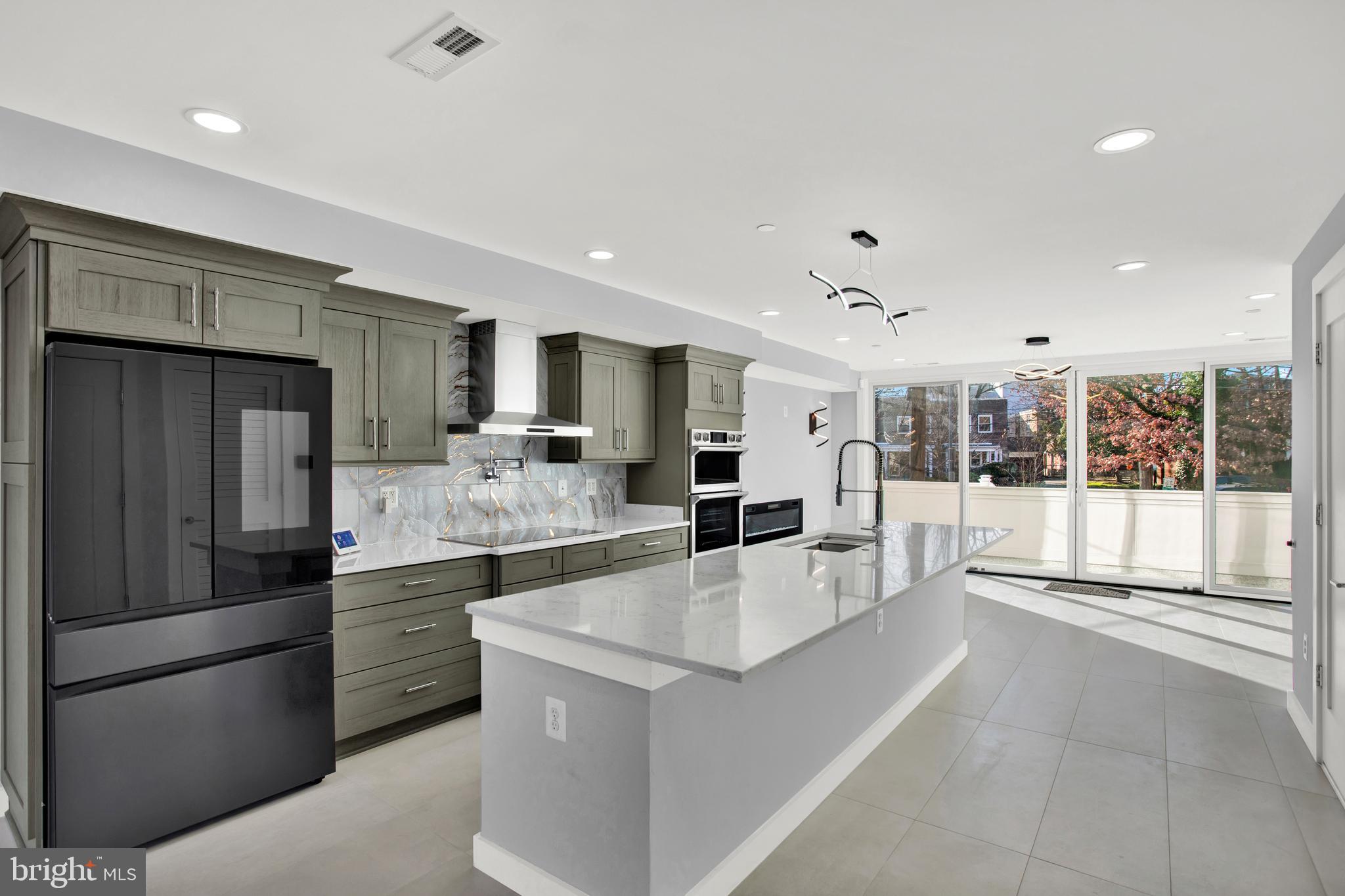 a large white kitchen with a large window and stainless steel appliances