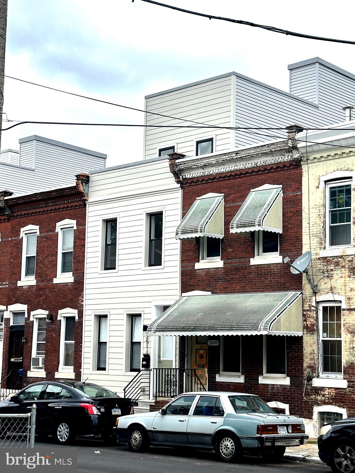 a front view of a building with car parked