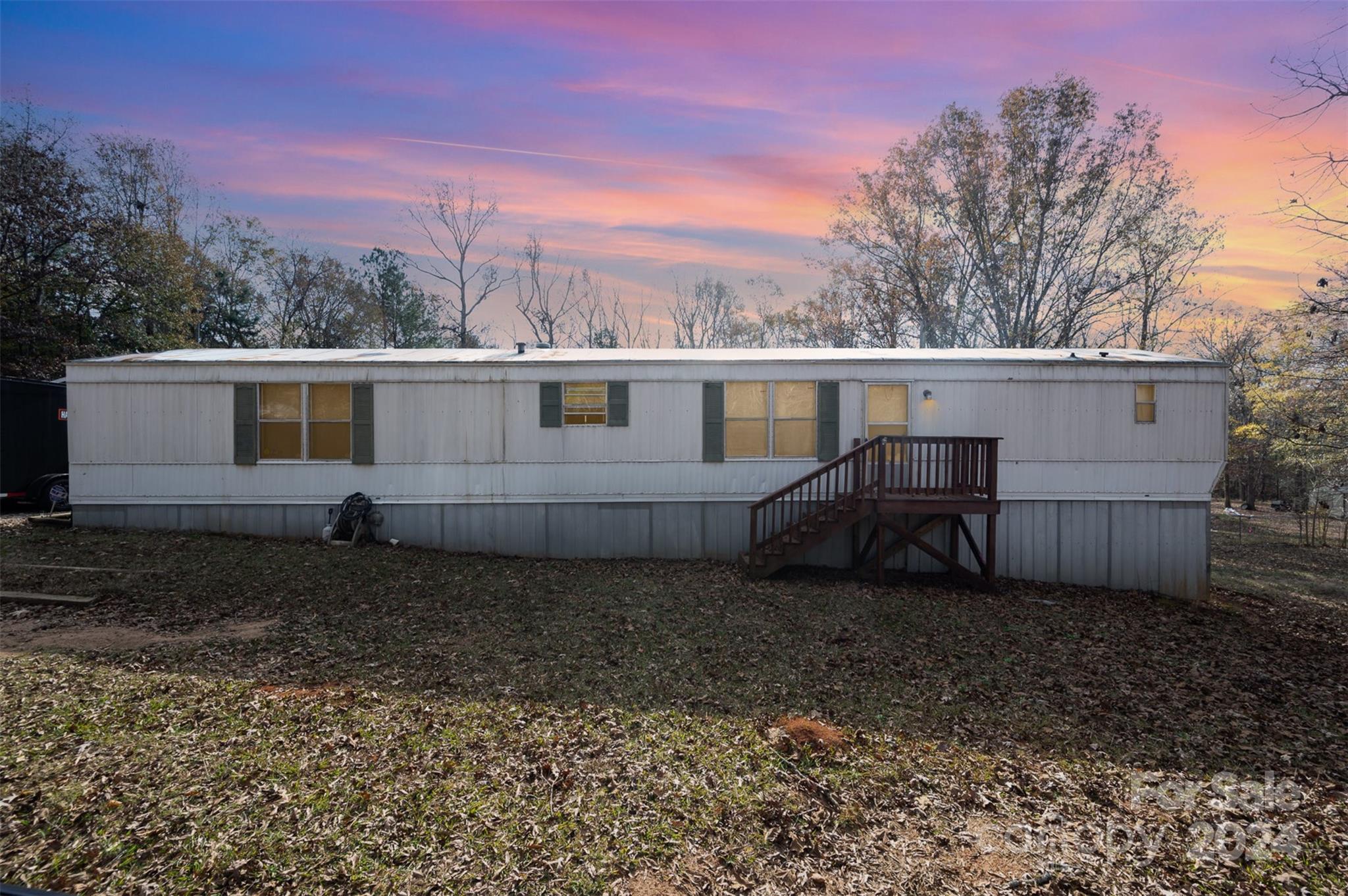 a view of a house with backyard and trees