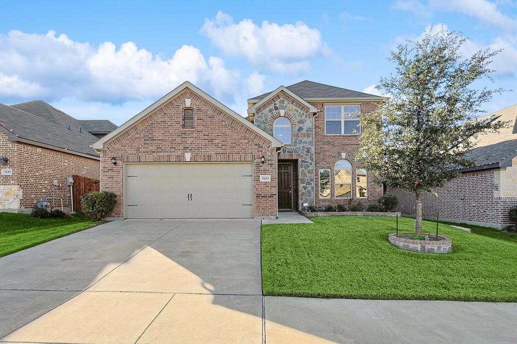 View of property with a front yard and a garage