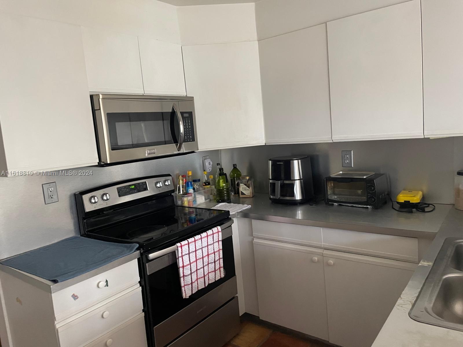 a kitchen with appliances a sink and cabinets