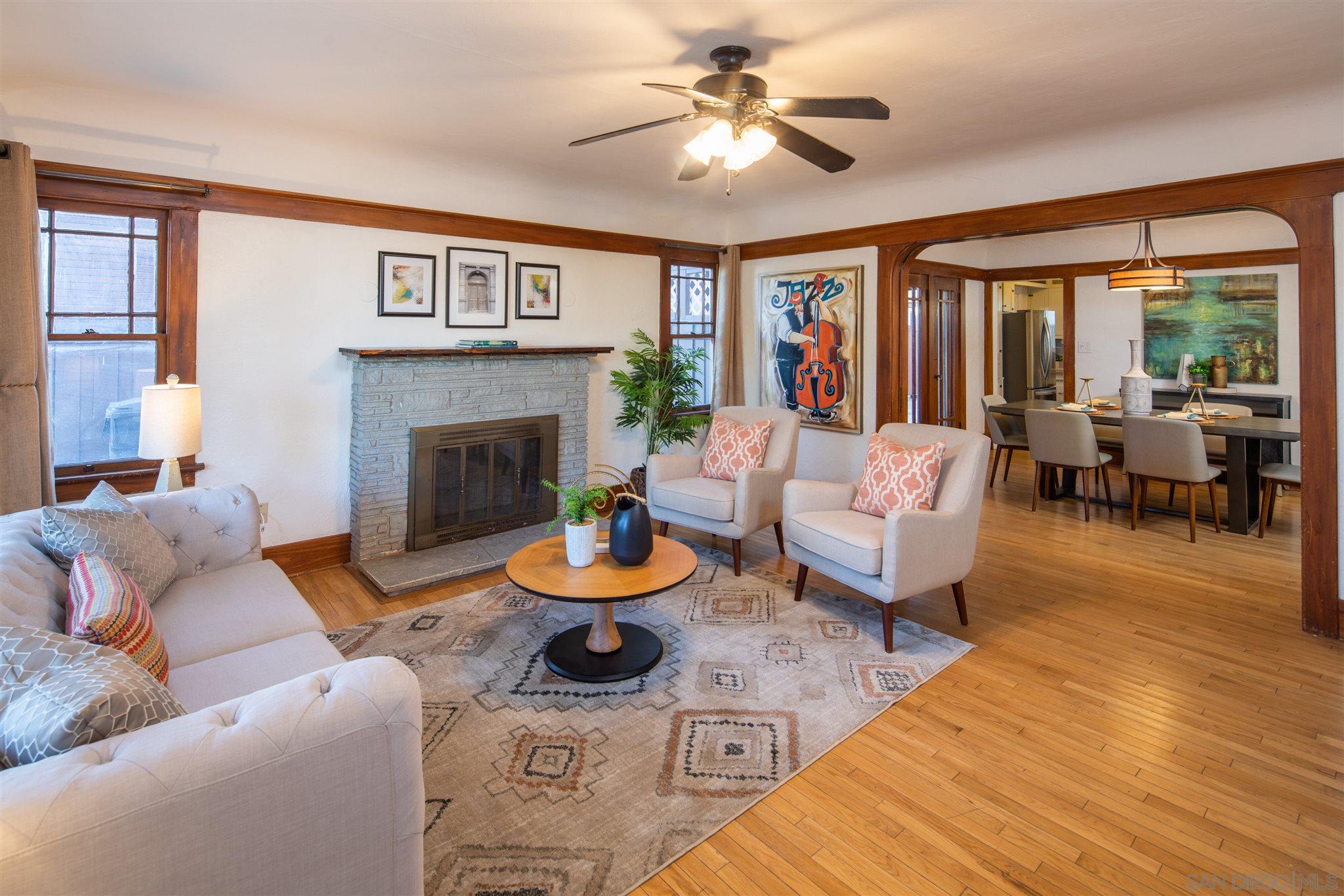 a living room with furniture a fireplace and a large window