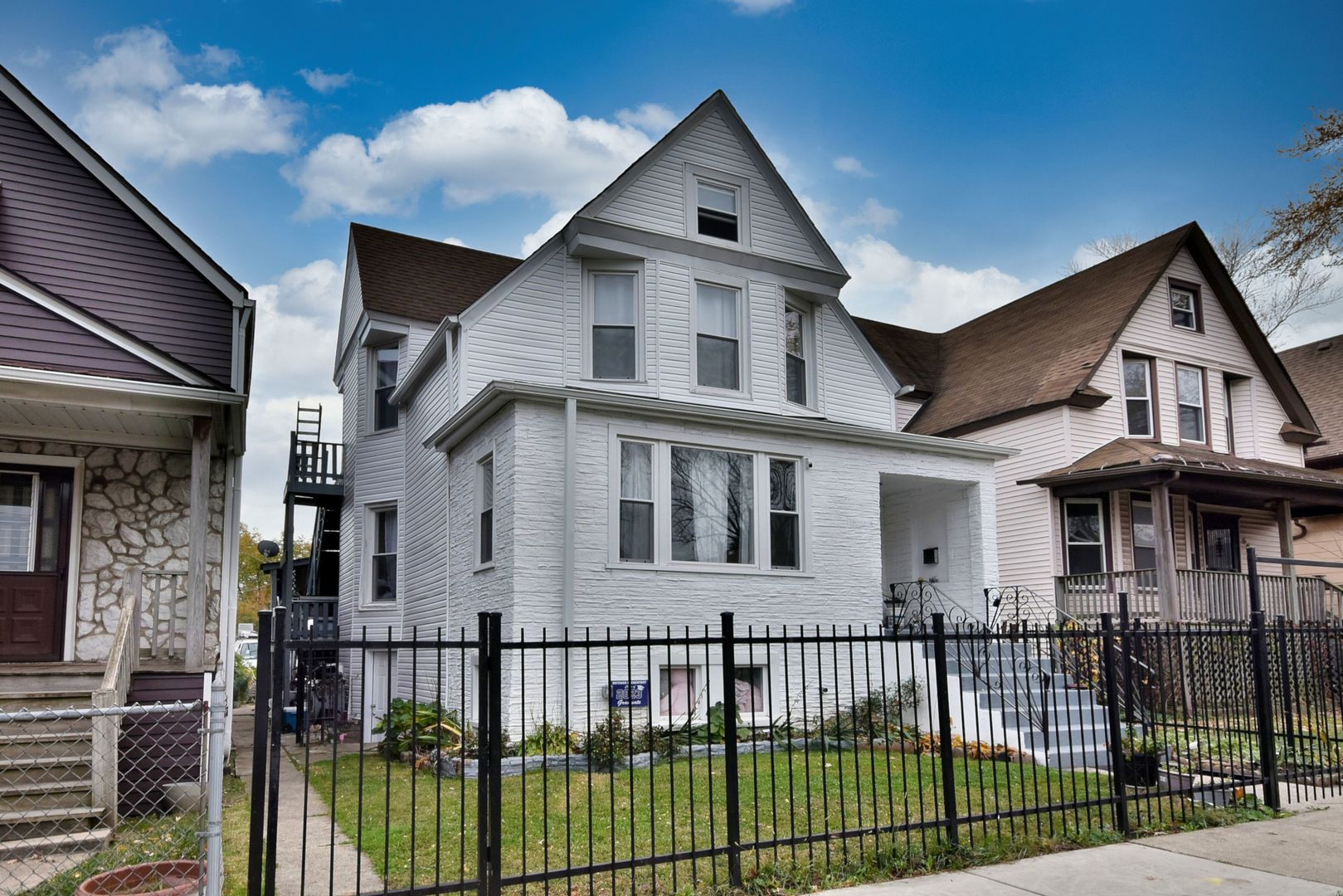 a front view of a house with iron fence