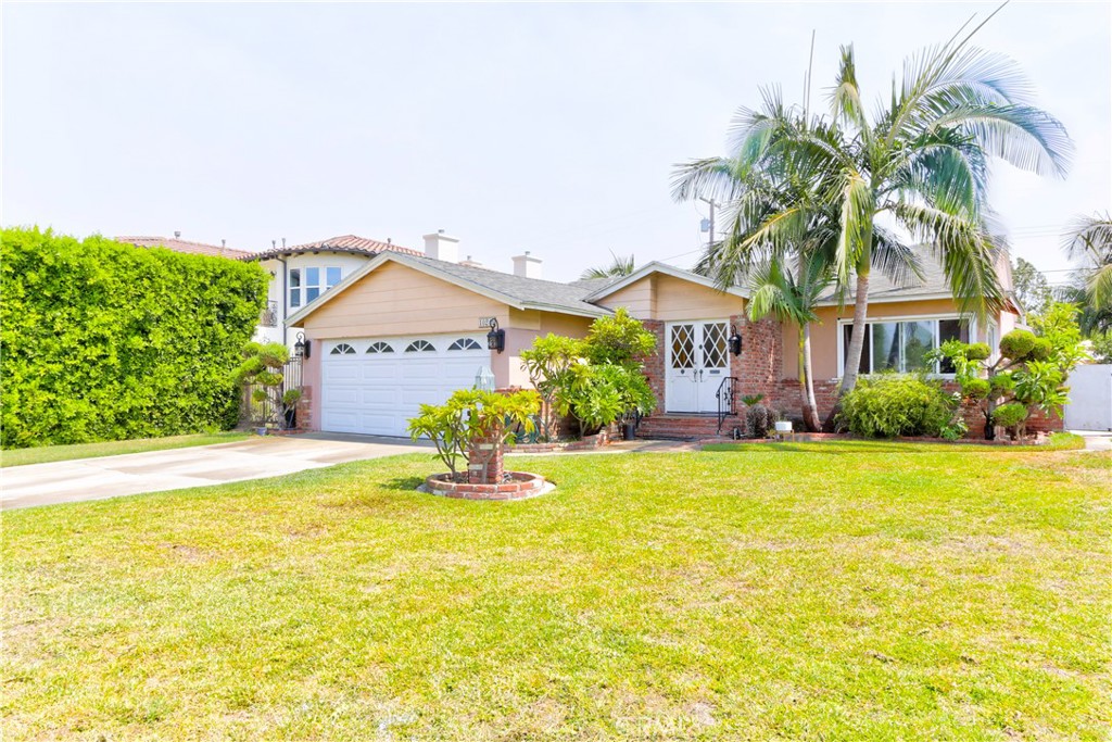 a very nice looking house with a large pool plants and palm trees