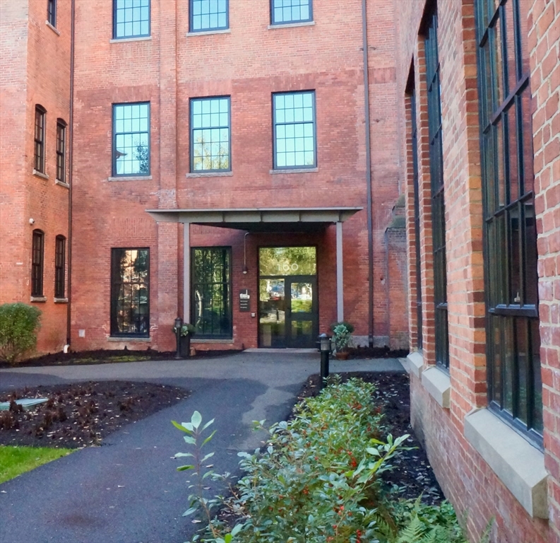 a front view of a brick building with a yard