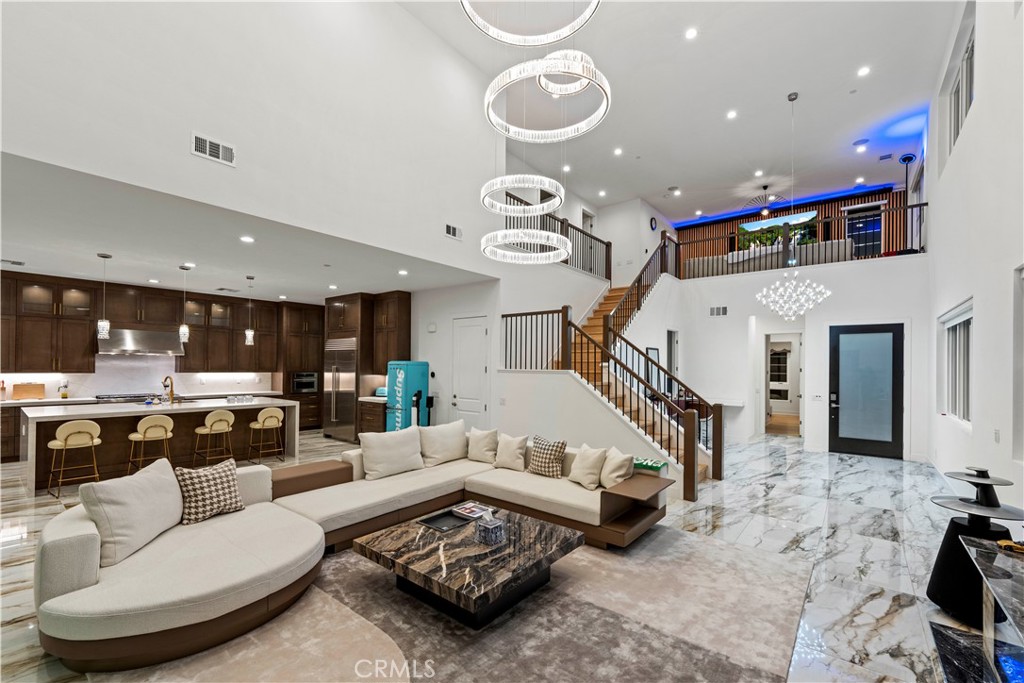 a living room with furniture kitchen view and a wooden floor