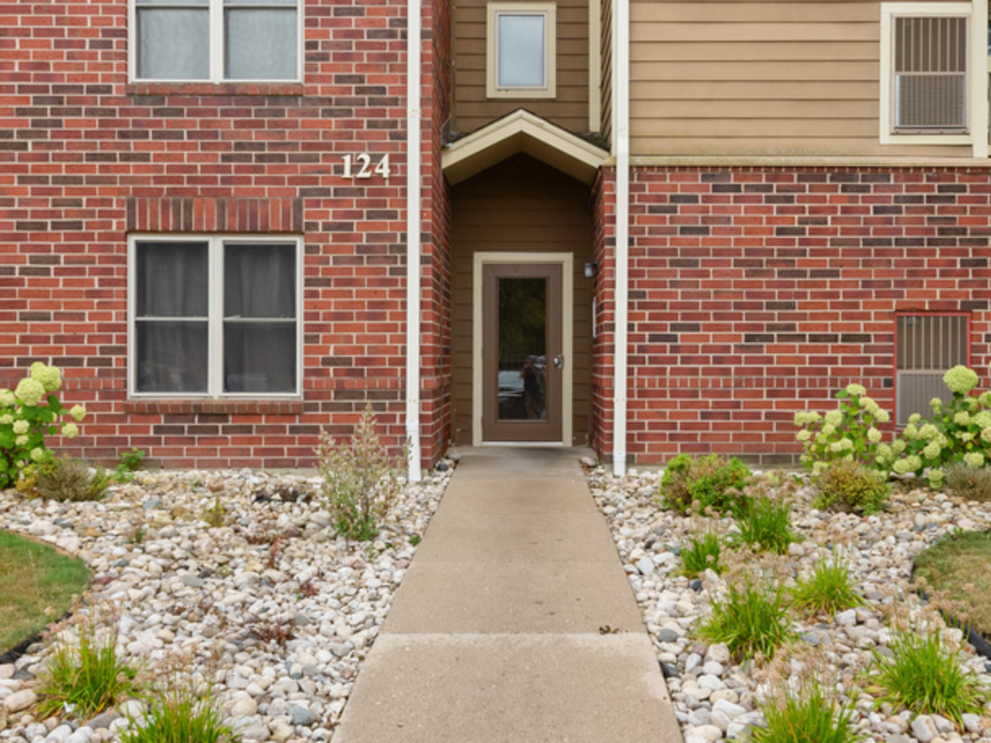 a pathway of a house with potted plants in front of door