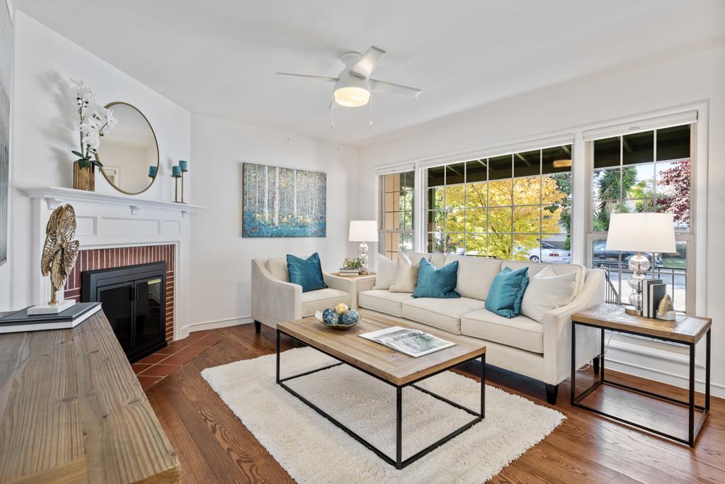 a living room with furniture a fireplace and a large window