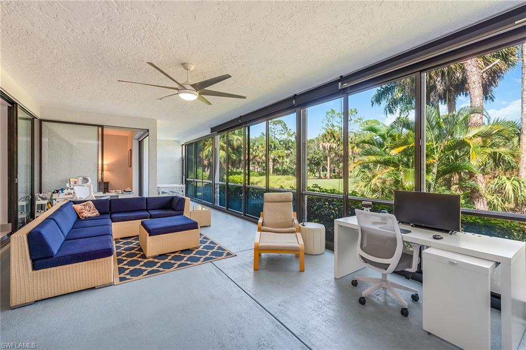 a living room with furniture and a floor to ceiling window