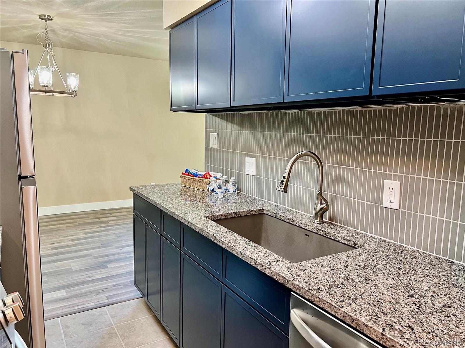 a kitchen with granite countertop stainless steel appliances a sink and cabinets