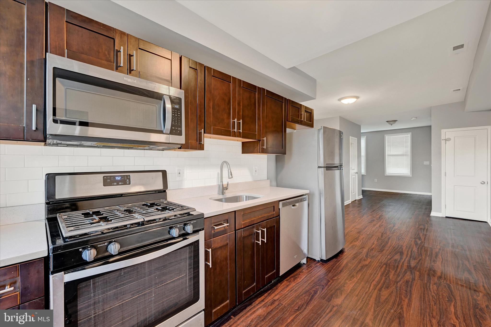 a kitchen with stainless steel appliances a stove sink and microwave